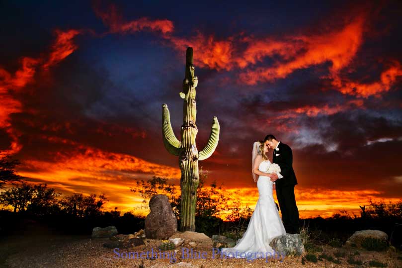 Couple kissing under a sunset at Tanque Verde ranch.  A must see when exploring Tucson Venues.